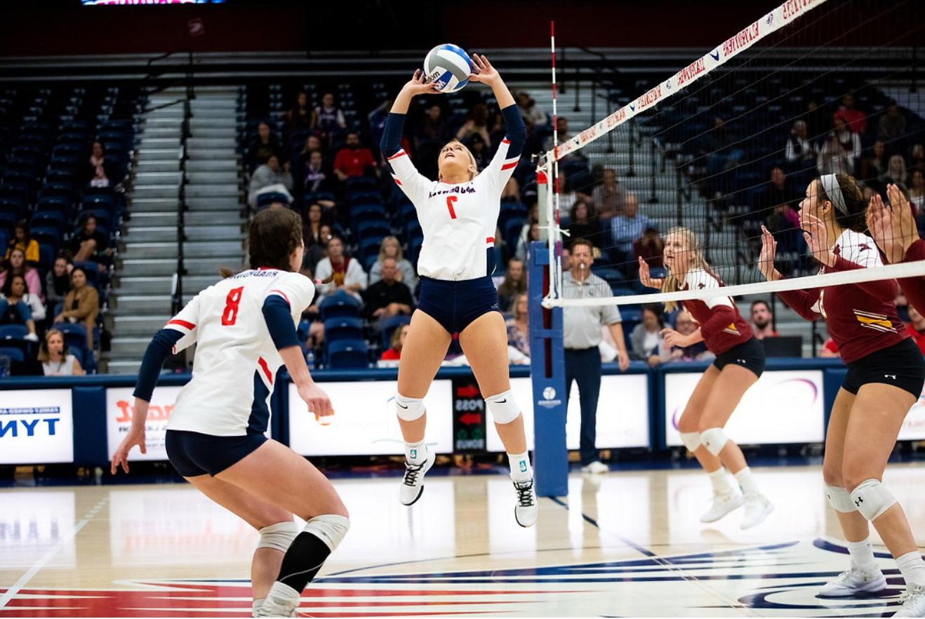 Women's volleyball team setting the ball